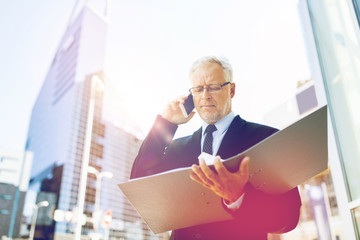 Fototapeta premium senior businessman calling on smartphone in city