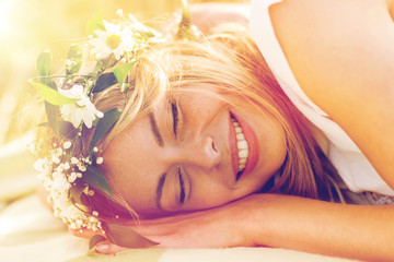 happy woman in wreath of flowers lying