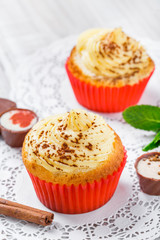 Tasty cupcakes with candies and chocolate on light background close up