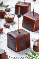 Chocolate souffle candy dessert with chocolate praline and cocoa beans on wooden background close up. Top view