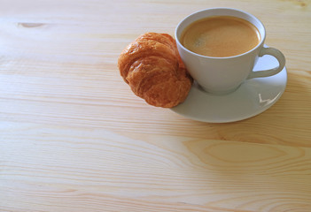 One Cup of Hot Coffee and a Butter Croissant on Wooden Table, with Free Space for Text or Design  