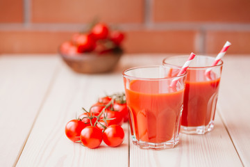 Tomato juice in a glass on wooden table. Love for a healthy raw food concept.