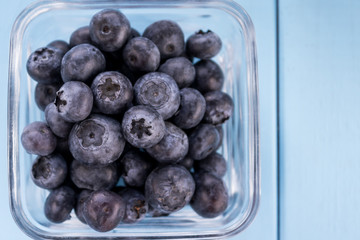 Freshly picked blueberries in the glass bowl, copy space