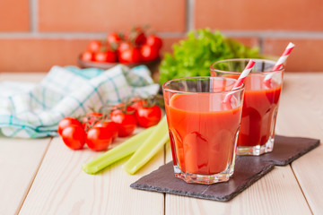 Tomato juice in a glass on wooden table. Love for a healthy raw food concept.