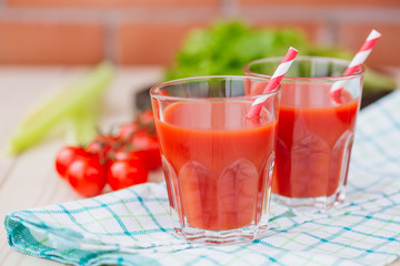Tomato juice in a glass on wooden table. Love for a healthy raw food concept.