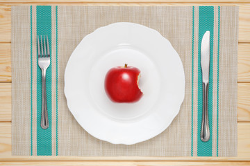 bitten red Apple on a white plate