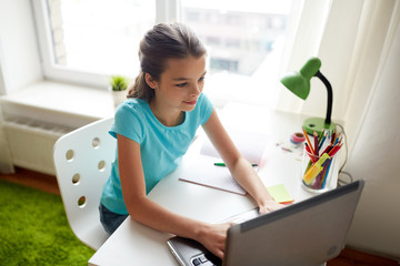 happy girl typing on laptop at home