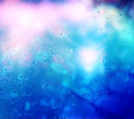 Abstract background: bright lights and raindrops on the glass. Night life. Disco. Youth.