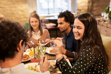 happy friends eating and drinking at restaurant