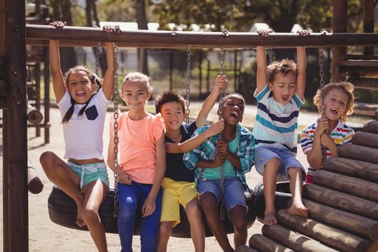 schoolkids having fun on tire swing
