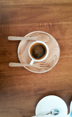 espresso coffee in white cup on wooden plate. top view.