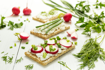 Light vegetarian lunch of raw vegetables with cottage cheese, herbs and radish on a white background. Healthy lifestyle, healthy eating.