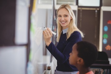 Portrait of teacher assisting schoolboy 
