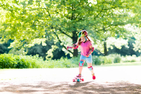 Child riding skateboard in summer park