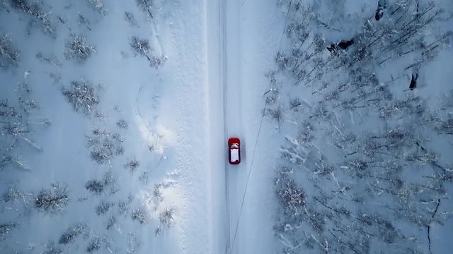 Aerial of a red car in the woods of norway