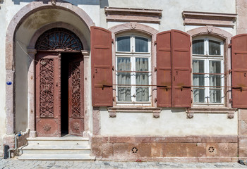 Fototapeta na wymiar Old house facade with iron wrought door and two windows at Urla, Izmir, Turkey