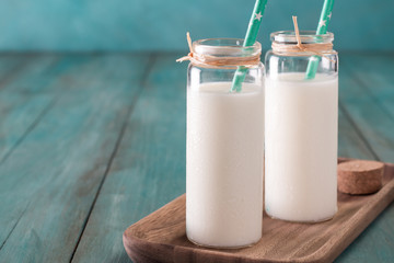 glass of milk on a wooden table on a blue background healthy food