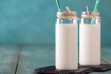 glass of milk on a wooden table on a blue background healthy food