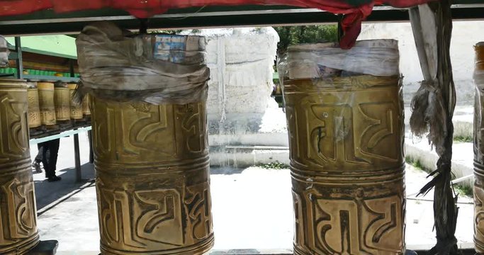 4k tibetan person turn spinning buddhist prayer wheels,lhasa.lhasa Tibetans wearing traditional clothing.