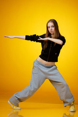 Fototapeta na wymiar teenager girl dancing hip-hop and looking in camera