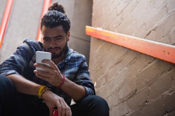 Man using mobile phone on staircase