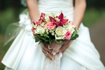 Obraz na płótnie Canvas Beauty wedding bouquet in bride's hands, close - up, bouquet of pion-shaped roses and ranunculus