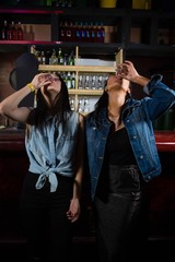 Female friends having tequila shot