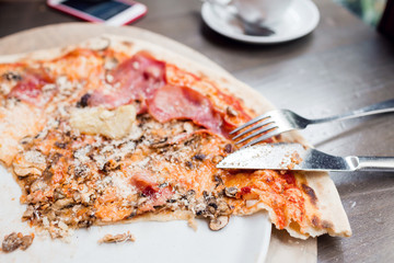 Pizza with artichoke, ham and mushrooms. the process of eating, cooking appliances