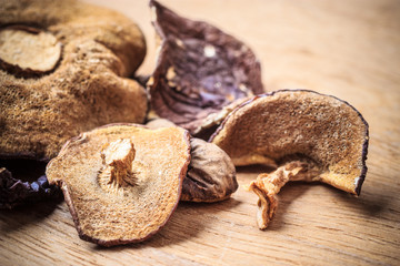 Dry mushrooms on wooden rustic table.