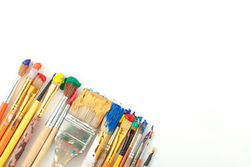Row of artist paintbrushes closeup on artistic canvas.