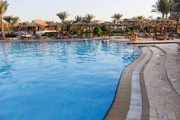 Fototapeta na wymiar swimming pool with palm trees at tropical resort