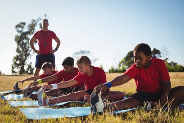 Trainer instructing kids while exercising in the boot camp