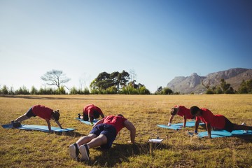 Trainer instructing kids while exercising in the boot camp