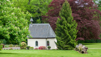 Small chapel in gardens with bell.