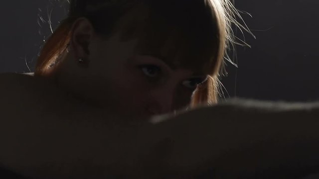 Beautiful strong woman kickboxer exercising in the gym, persistence and power