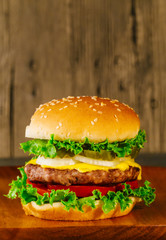 Classic deluxe cheeseburger with lettuce, onions, tomato and pickles
