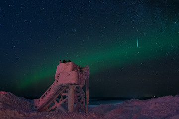 Torretta di osservazione dell'aurora boreale completamente ghiacciata con un'aurora verde ed una...