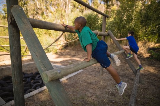Boys exercising on outdoor equipment during obstacle course