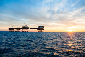 Silhouette of an offshore oil platform at sunset 