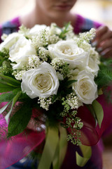 White roses bouquet; young lady holds bouquet of white roses; selective focus.