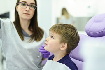 Fototapeta premium A little boys first check up. Kid visits the dentists office for the first time