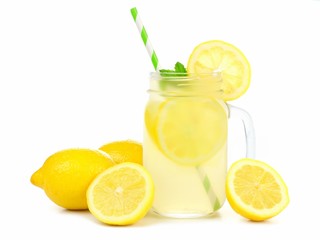 Mason jar glass of lemonade with lemons and straw isolated on a white background