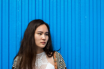 Portrait of young cute woman standing on the blue background