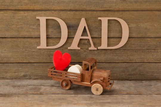 Toy truck with red heart against text dad - Powered by Adobe