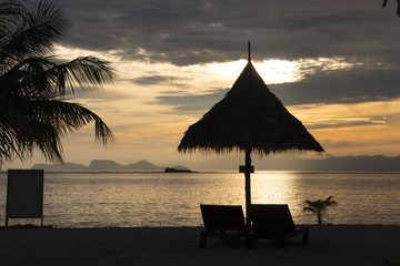 Silhouette of  pavilion with bed beach in sunset background
