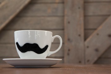Cup and saucer with fake moustache