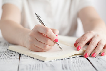 Young female is writing notes and planning her schedule