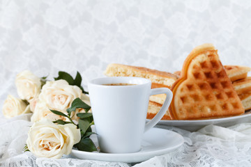 beautiful white cup of black coffee and rose flower on a white background