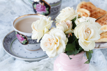 Obraz na płótnie Canvas Chain drinking hot tea on a wooden floor with beautiful roses.