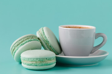 French macarons and coffee cup on aquamarine background